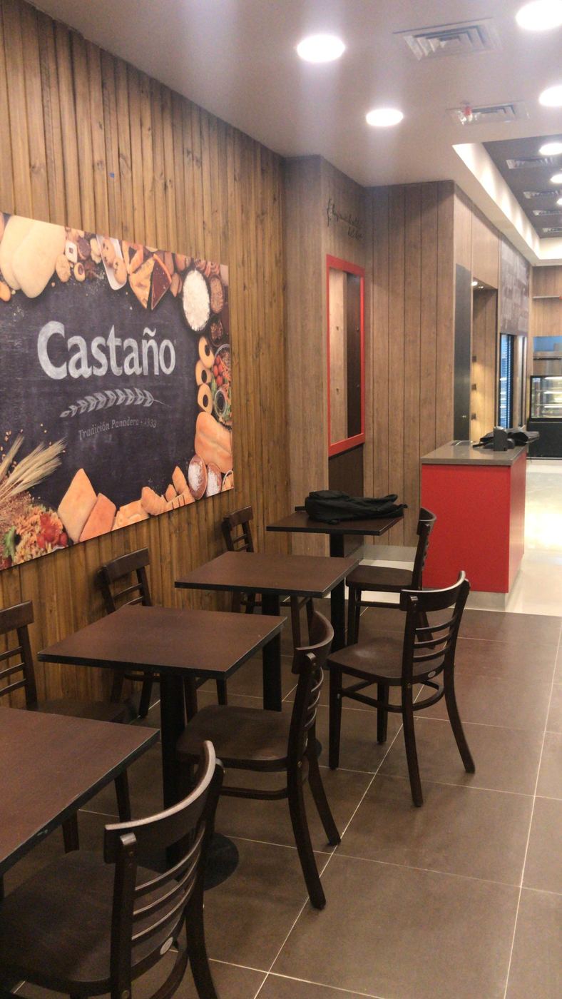 Zona de mesas con muro de madera y gráfica de Castaño