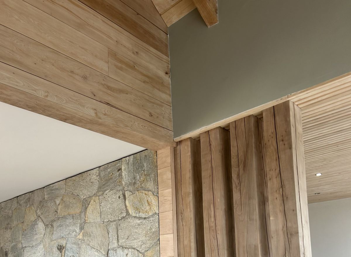 Pilares de madera nativa junto al muro de piedra