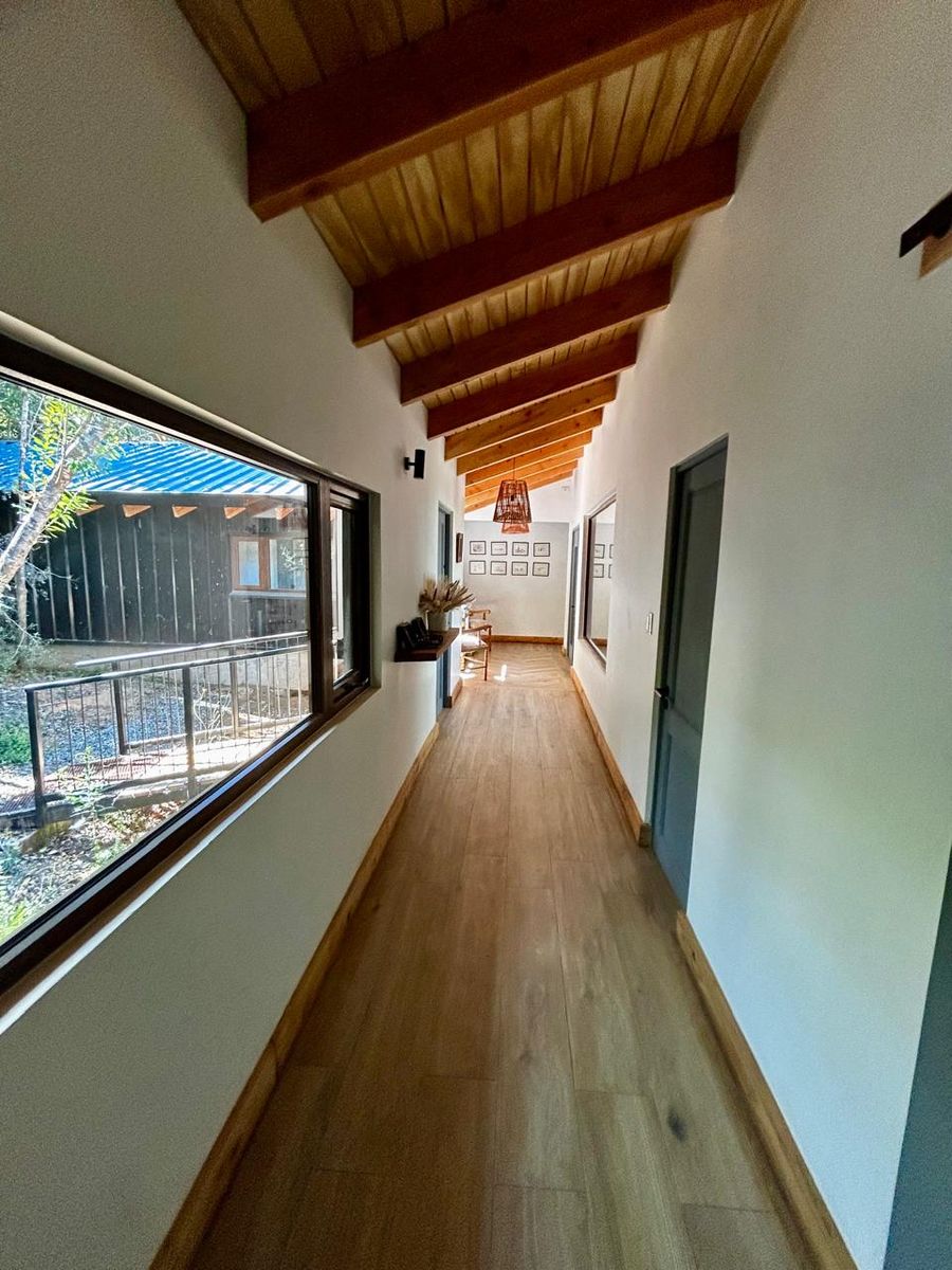 Pasillo de dormitorios con cielo de madera