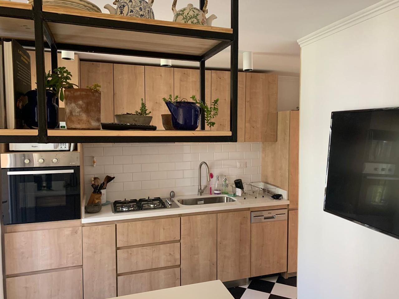 Cocina remodelada con repisa colgante de fierro y madera
